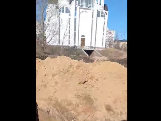Братська могила біля церкви у Бучі — скрін