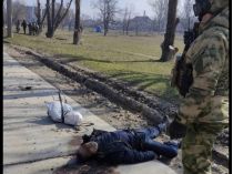 російські військові фотографуються з тілами вбитих ними мешканців Маріуполя