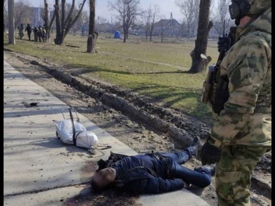 российские военные фотографируются с телами убитых ими жителей Мариуполя