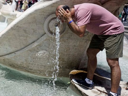 Итальянец освежает голову водой из фонтана