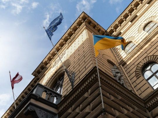 Будівля Сейму Латвії з прапорами республіки, України та ЄС