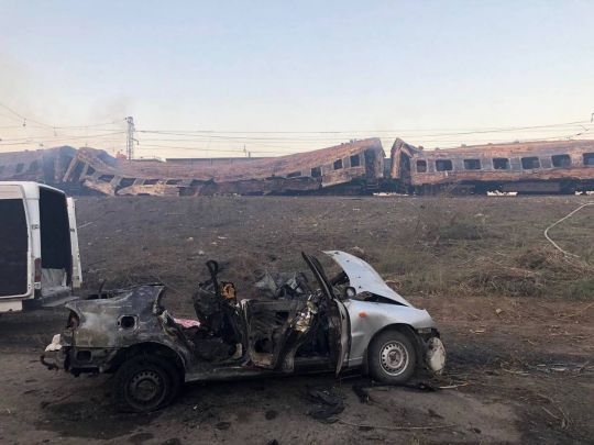 Сгоревшие пассажирские вагоны после обстрела станции Чаплино