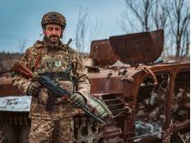 Український захисник поруч зі спаленим танком рф