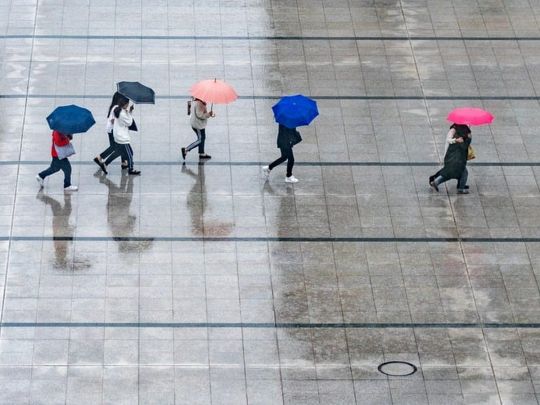 Люди під парасольками