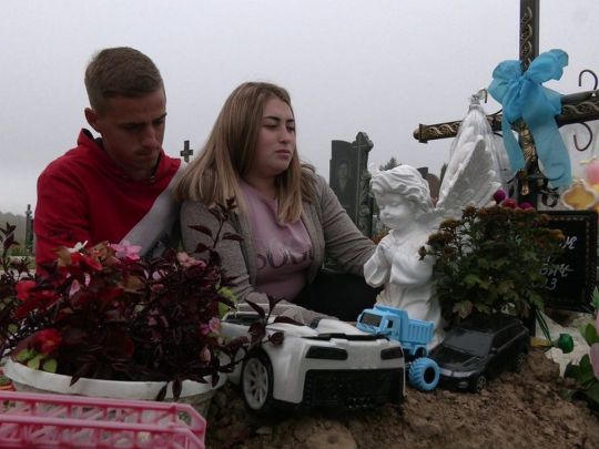 Дарья и Николай Юфимчук на могиле своего сыночка Тимофея