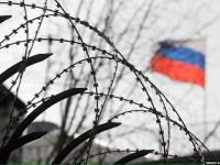 российский флаг за колючей проволокой