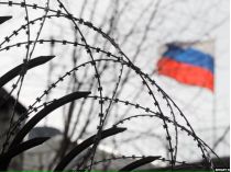 российский флаг за колючей проволокой