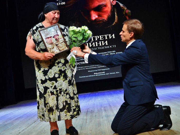 Ведущий Глеб Кудряшов встал на колени перед Екатериной Григорьевной, мамой погибших братьев Швецов. Фото А. Розума